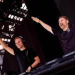 Armin van Buuren et David Guetta se produisant ensemble sur scène à l'Ushuaïa Ibiza, souriant et levant les bras.